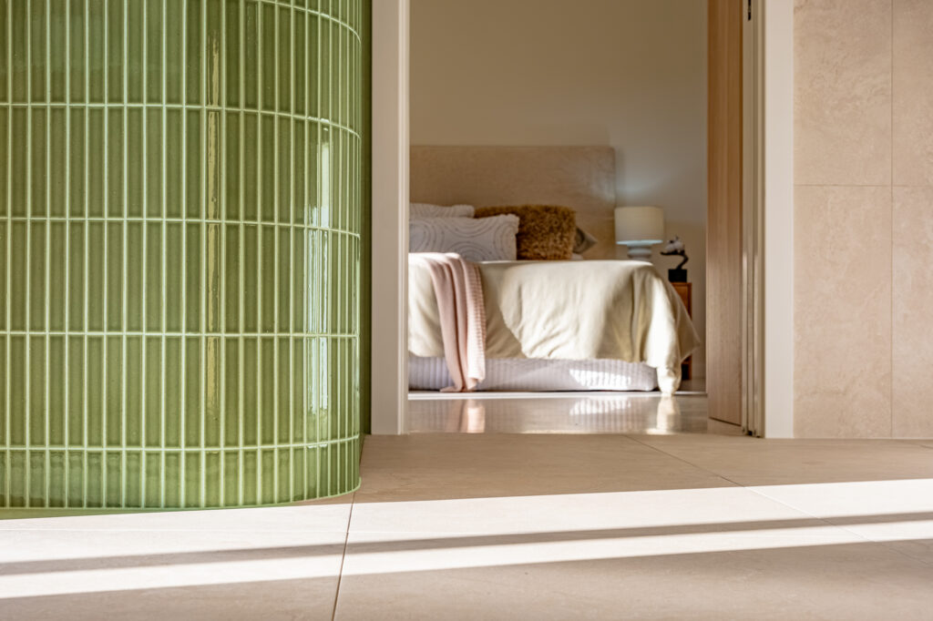 Curved green tiled wall beside the main bedroom
