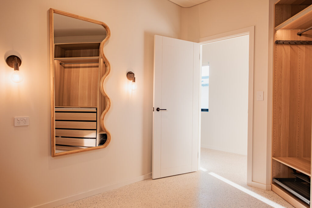 Walk-in robe with a wavy timber mirror